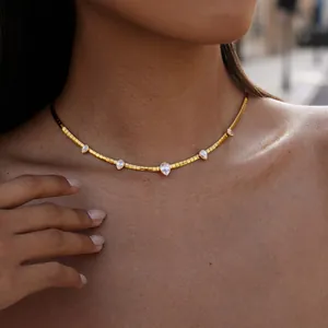 Goldene Schlangenkette aus Edelstahl mit birnenförmigen Zirkonia-Anhängern am Modell