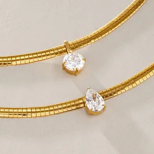 Nahaufnahme goldener Schlangenkette mit rundem und birnenförmigem Zirkon-Anhänger