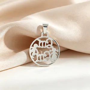 Détail macro d'un pendentif évidé en acier titane poli avec motif mère et enfant sur soie