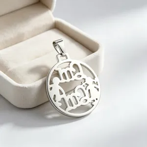 Détail d'un pendentif mère-enfant ajouré en acier inoxydable placé dans un écrin.