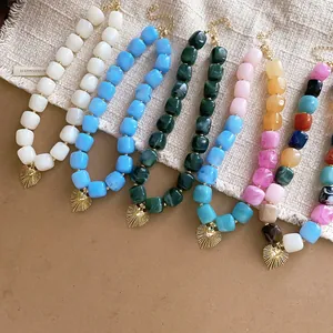 Close-up of resin square bead necklaces with textured gold heart pendants