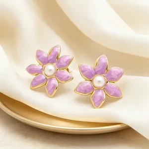 Gros plan détaillé des boucles d'oreilles vintage fleurs en émail violet et perles