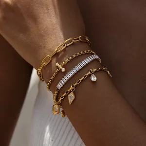 Nahaufnahme eines Sets aus 18K vergoldeten Edelstahlarmbändern mit Zirkonia-Anhängern.