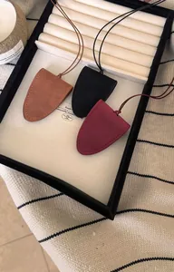 Détail de colliers porte-lunettes en cuir minimalistes en trois couleurs sur un plateau