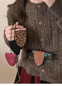 Gros plan d'un collier porte-lunettes multifonctionnel en cuir porté par un mannequin.
