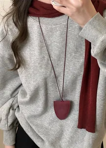 Collier porte-lunettes bordeaux en cuir véritable porté par un mannequin avec écharpe