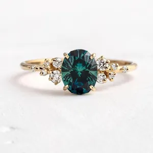 Vista dettagliata di un anello in oro con gemma ovale ottanio e diamanti a grappolo