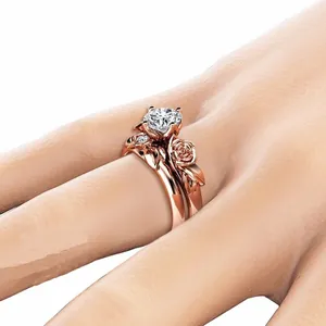 Vista dettagliata del set di anelli in oro rosa con design floreale e pietre di zircone