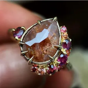Close-up detail of a vintage pear-cut zircon ring with multi-color gemstone accents.