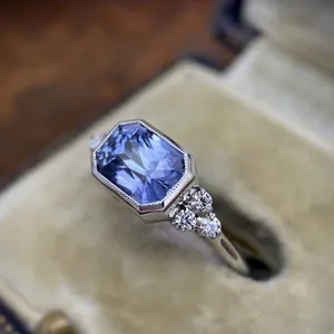 Vintage engagement ring with a light blue gemstone shown in a classic velvet jewelry box