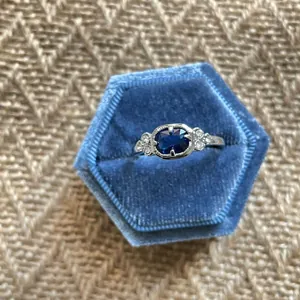 Elegant vintage blue gemstone silver ring presented in a blue hexagonal velvet jewelry box