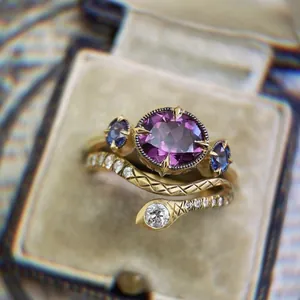 Detalle macro de anillo vintage de oro con piedras púrpuras y banda en forma de serpiente