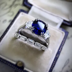Close-up detail of luxury deep blue cushion cut zircon engagement ring set in a vintage velvet box