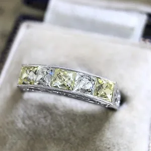 Macro detail of a vintage silver alloy ring featuring five square yellow zircon stones.