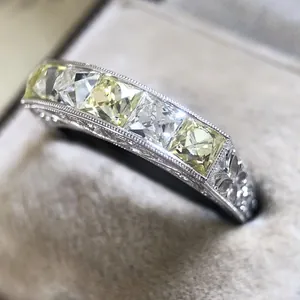 Detailed macro shot of princess-cut yellow and white zircon stones on silver alloy ring