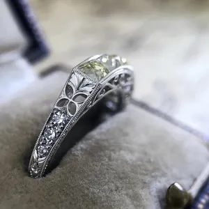 Close-up detail of vintage engraved silver ring with yellow and white zirconia stones