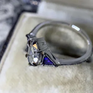 Close-up detail of a vintage style silver engagement ring with purple side gems