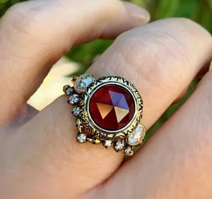 Detail shot of vintage gold ring with large hexagonal red stone and skull accents