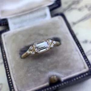 Detailed view of a vintage emerald-cut zircon engagement ring with gold finish in a box