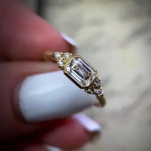 Close-up of a vintage emerald cut zircon engagement ring in a gold alloy setting