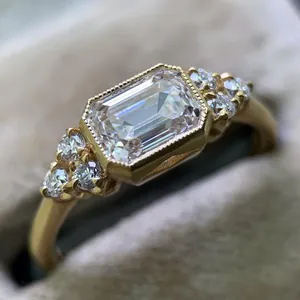 Detailed macro shot of an emerald cut zircon gold ring with vintage milgrain details.