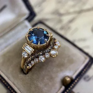 Macro view of vintage style gold engagement ring set with blue and white stones