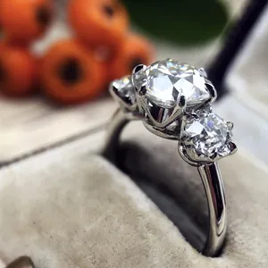 Macro detail shot of a classic silver-tone three-stone engagement ring with sparkling zircon