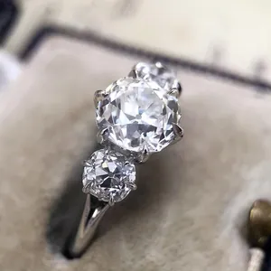 Primer plano de elegante anillo de compromiso de tres piedras con circonitas en aleación de plata.