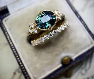 Macro shot of a vintage engagement ring set with a dark green oval zircon stone
