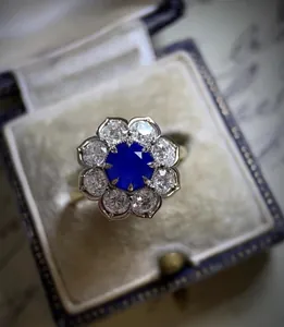 Detailed macro view of vintage style floral engagement ring with a blue sapphire center stone
