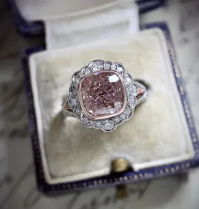 Macro detail of a vintage-style ring with a pink cushion-cut stone in a velvet box.