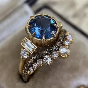 Elegant vintage gold engagement ring set featuring large blue center stone and floral band