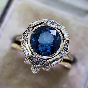 Vintage gold plated halo ring set with large dark blue round cubic zirconia stone