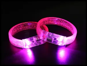 Macro detail shot of two pink glowing LED acrylic bracelets for parties and music concerts