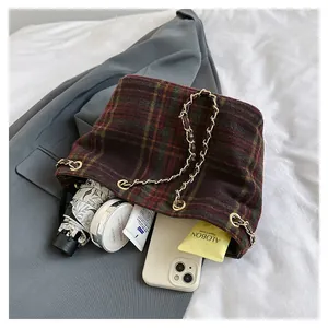 Gros plan d'un sac seau en laine à carreaux rétro avec chaîne dorée et grande capacité