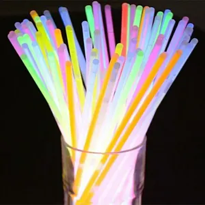 A bunch of colorful glowing neon sticks in a glass container on a black background