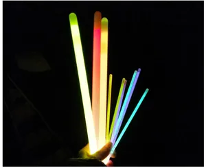 Close-up detail showing the vibrant colorful glowing effect of neon light sticks in the dark