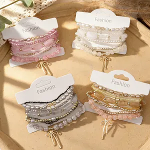Bohemian style beaded bracelet set featuring elegant bow charms and faux pearls for stacking