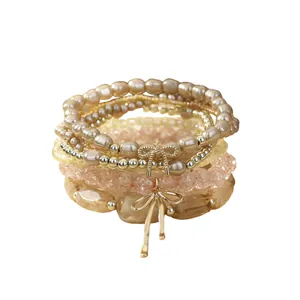 Bohemian layered bracelet set featuring glass beads, imitation pearls and bow charms
