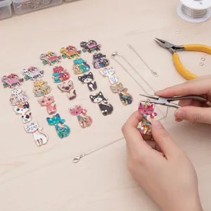 Detailed close-up showing the manual assembly of a cartoon cat pendant necklace DIY project