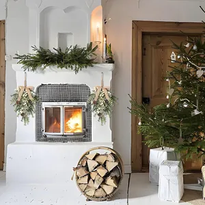 Festive Christmas teardrop swags displayed on a cozy white fireplace with a warm fire.