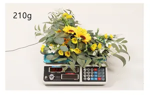 Close-up of artificial sunflower decoration on a scale showing 210g weight