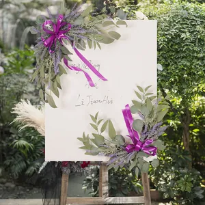 Wedding welcome board with lavender and eucalyptus artificial flowers and purple ribbons