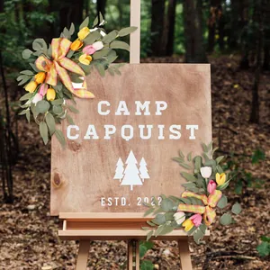Artificial tulip floral swags for rustic wedding welcome signs in a forest setting