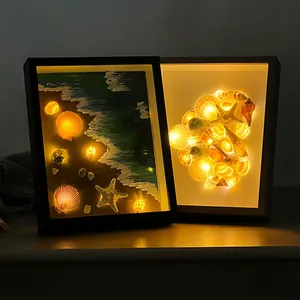 Detailed view of 3D shadow box frames with warm LED lights and seashell art décor
