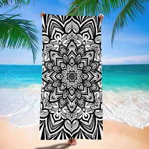 Detailed black and white mandala print on a microfiber beach towel at a tropical beach