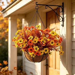 Close-up of artificial orange and yellow flowers in a coco liner hanging basket on a porch