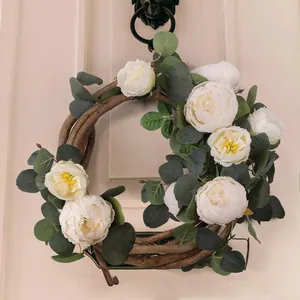 Elegant white peony and eucalyptus leaf floral wreath on a natural rustic wood vine base