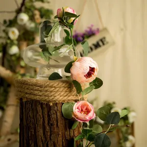 Close-up detail of artificial pink peony and eucalyptus vine for home wedding decoration