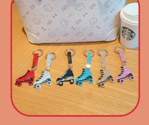 Porte-clés colorés en forme de patins à roulettes ornés de strass sur table en bois